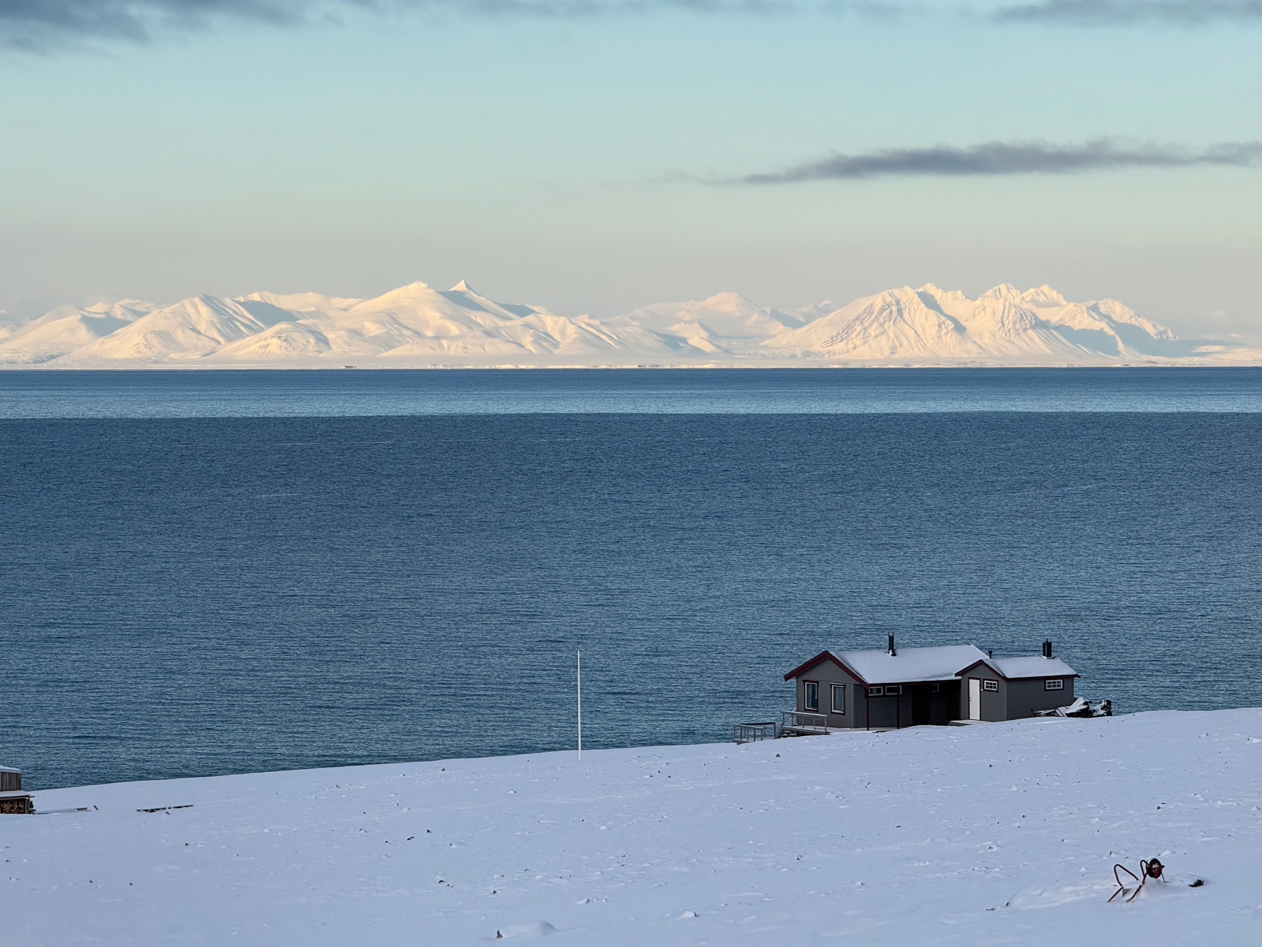 峡湾边的小木屋与雪山